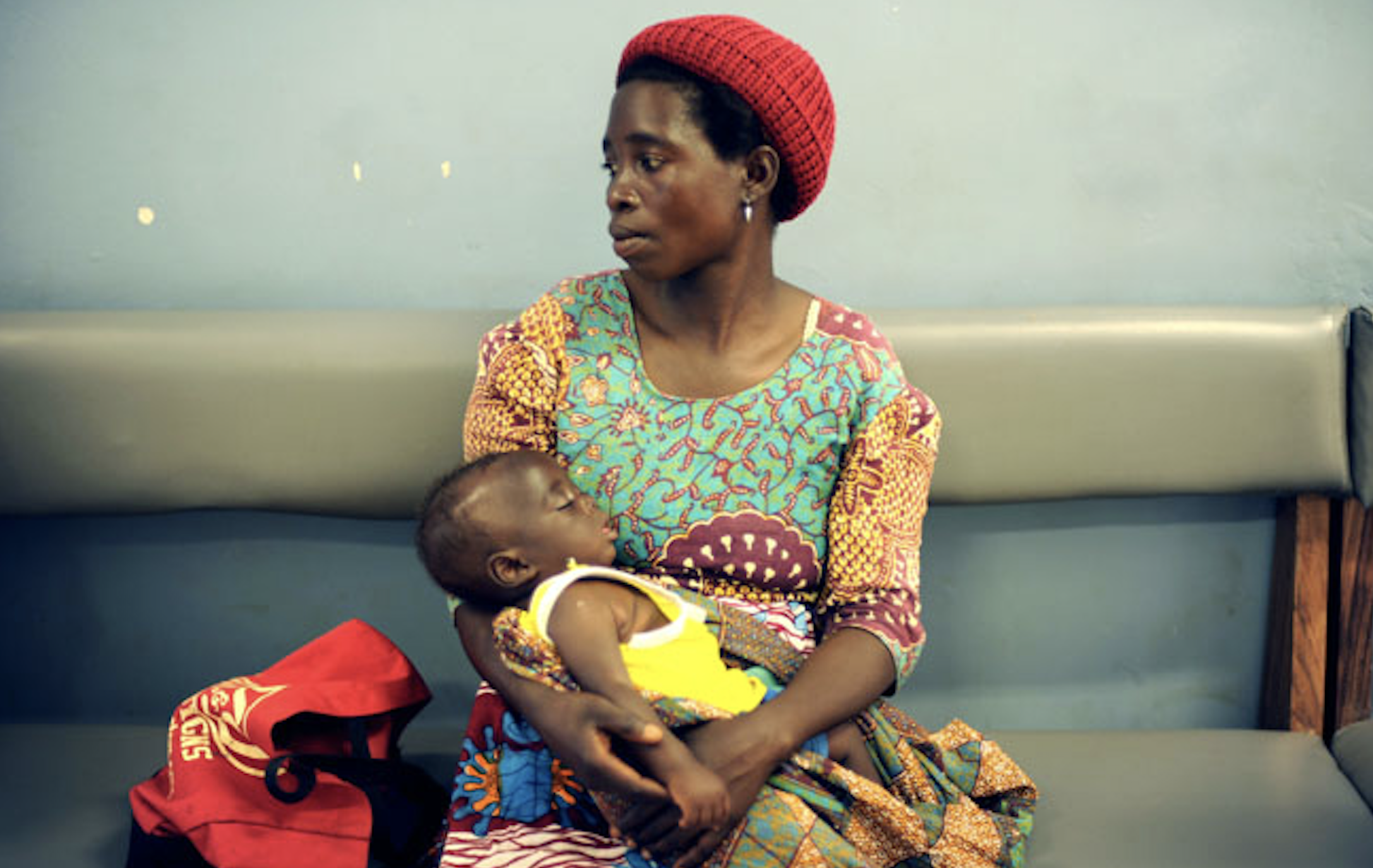 African woman holding a baby in her arms at a hospital